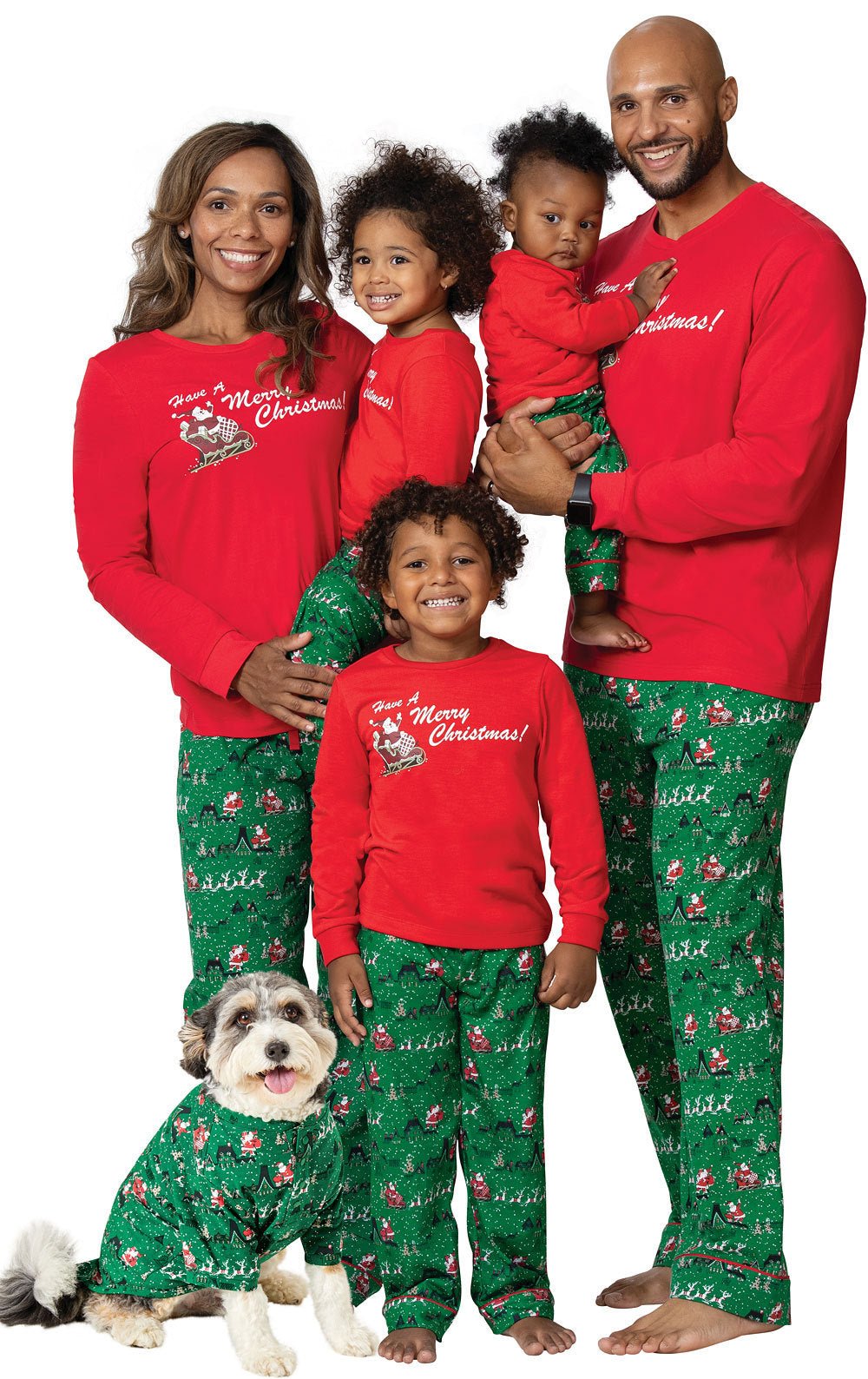 Famiglia e cane in posa su sfondo bianco con maglie rosse Merry Christmas, pantaloni verdi del pigiama a stampa festiva e camicia coordinata per animale domestico.