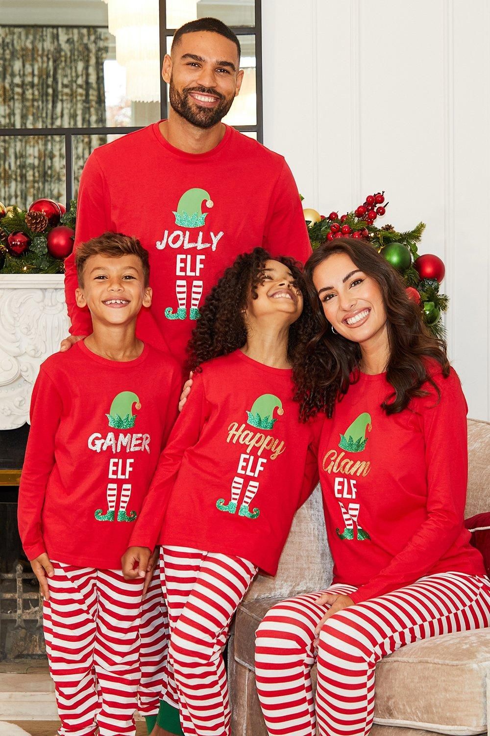 Famiglia con maglie rosse del pigiama Jolly Elf, Gamer Elf, Happy Elf e Glam Elf e pantaloni a righe rosse e bianche.