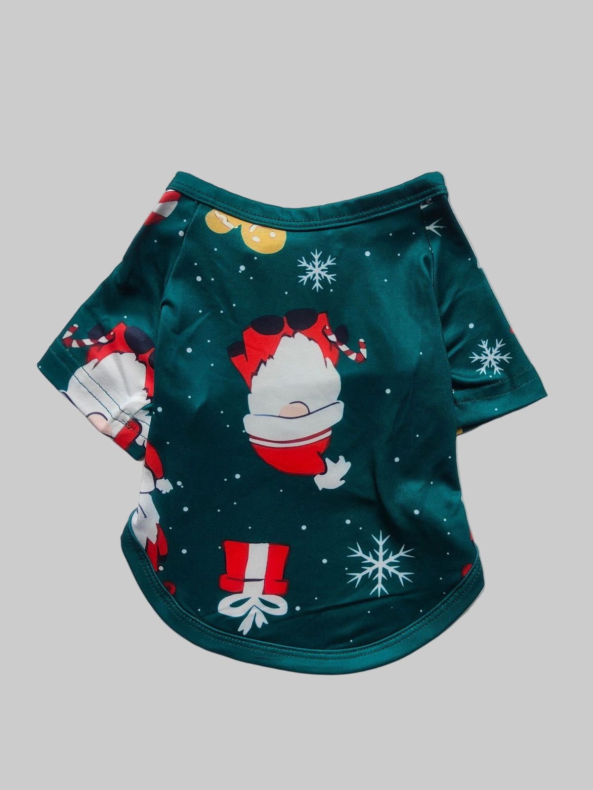 Camicia natalizia verde a maniche corte per cane con Babbo Natale, regali e fiocchi di neve, disposta in piano su sfondo grigio.