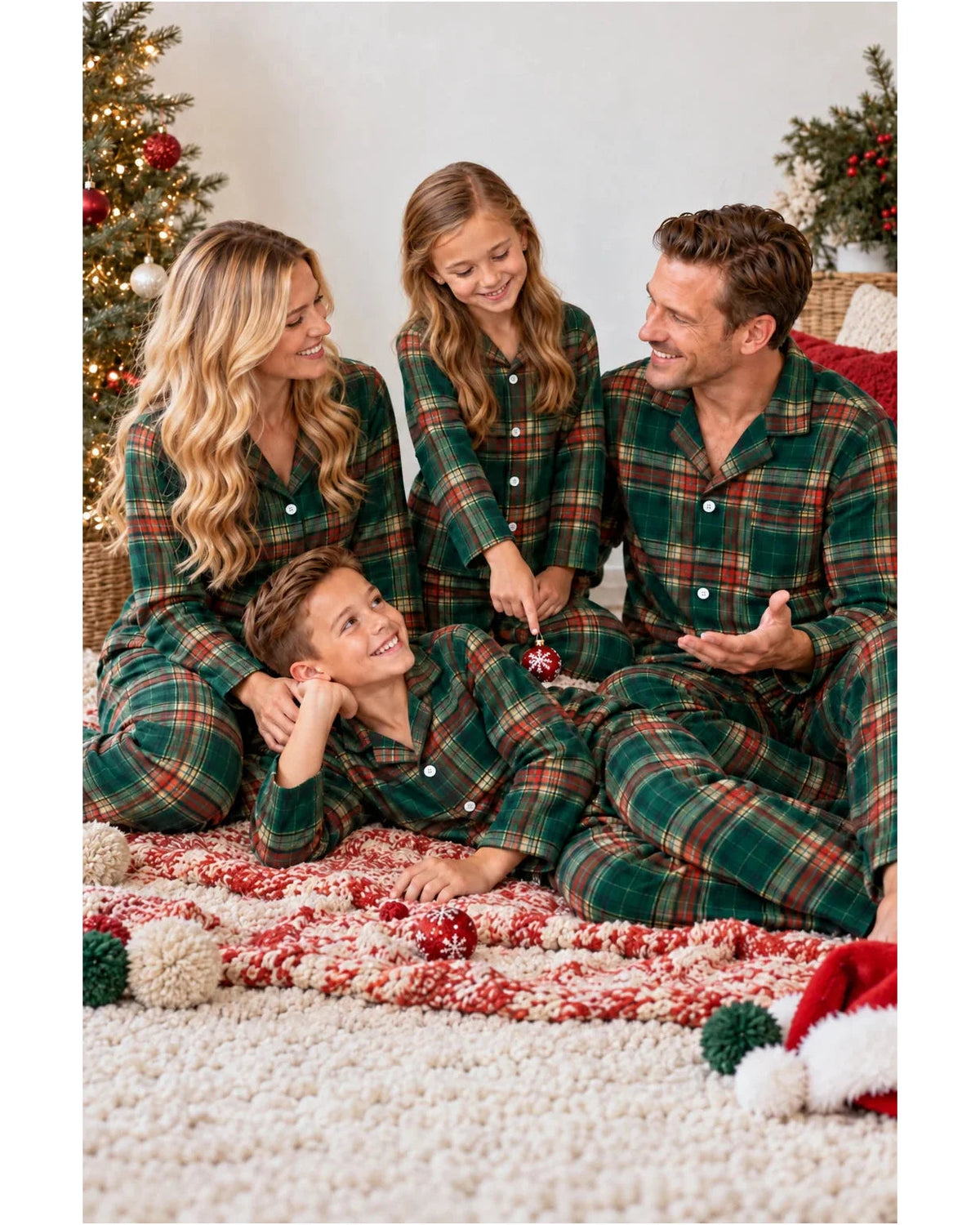 Family in light green tartan pajamas relaxing on a bed with Christmas ornaments.