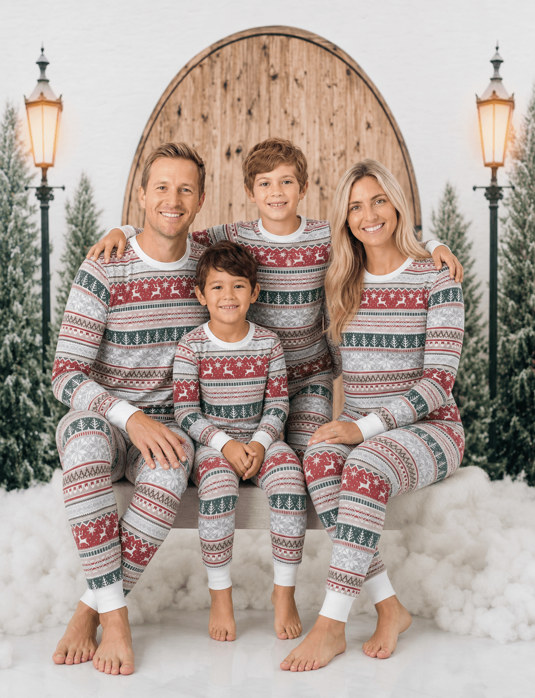 Family posing in front of a wooden door in red, green and white Fair Isle Christmas pajamas with white cuffs.