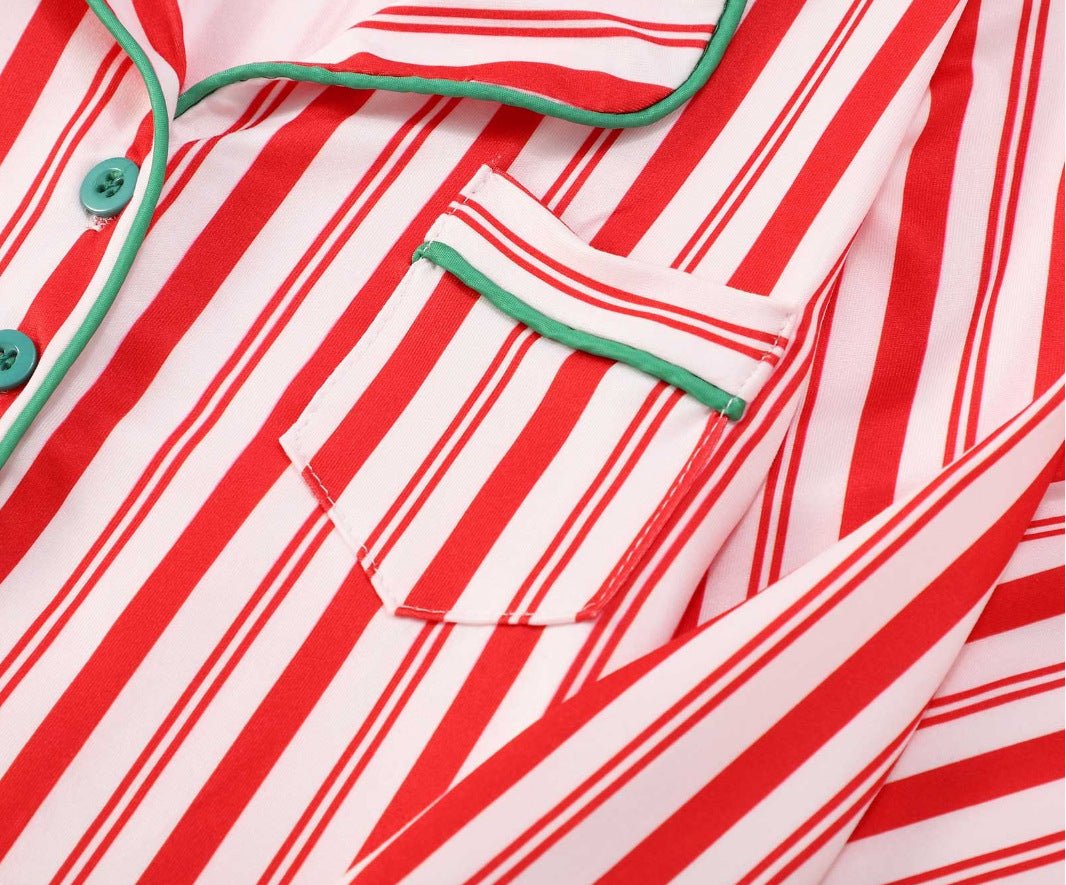Close-up of the collar, green buttons and green piping around a chest pocket on red-and-white striped pajamas.