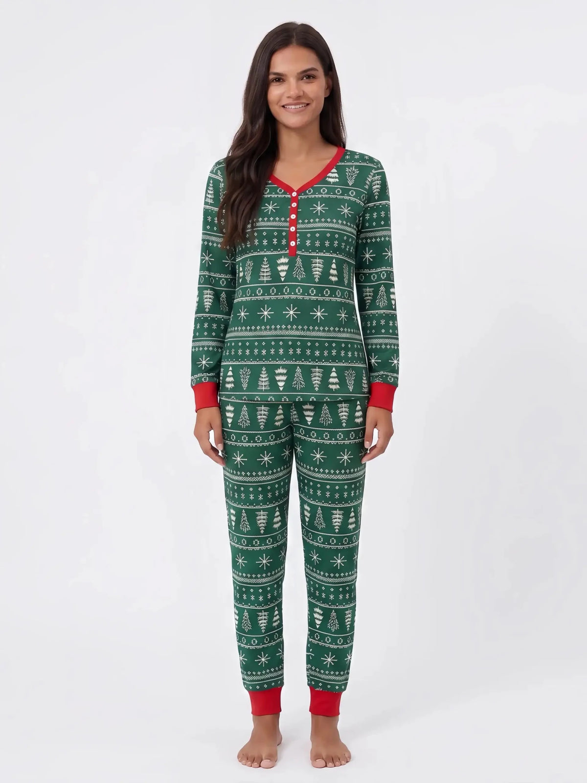 Donna che presenta un pigiama natalizio verde con alberi e fiocchi di neve bianchi, abbottonatura rossa e polsini rossi.