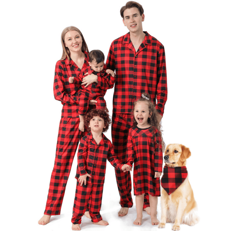 Family in red and black buffalo plaid sleepwear posing beside a dog wearing a matching triangular bandana.