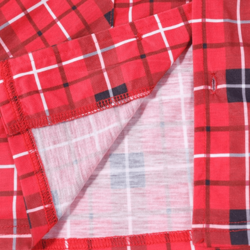 Nahaufnahme eines gefalteten roten Tartan-Pyjamasaums mit Innenseite des Stoffes, Nähten sowie schwarzen und weißen Karolinien.