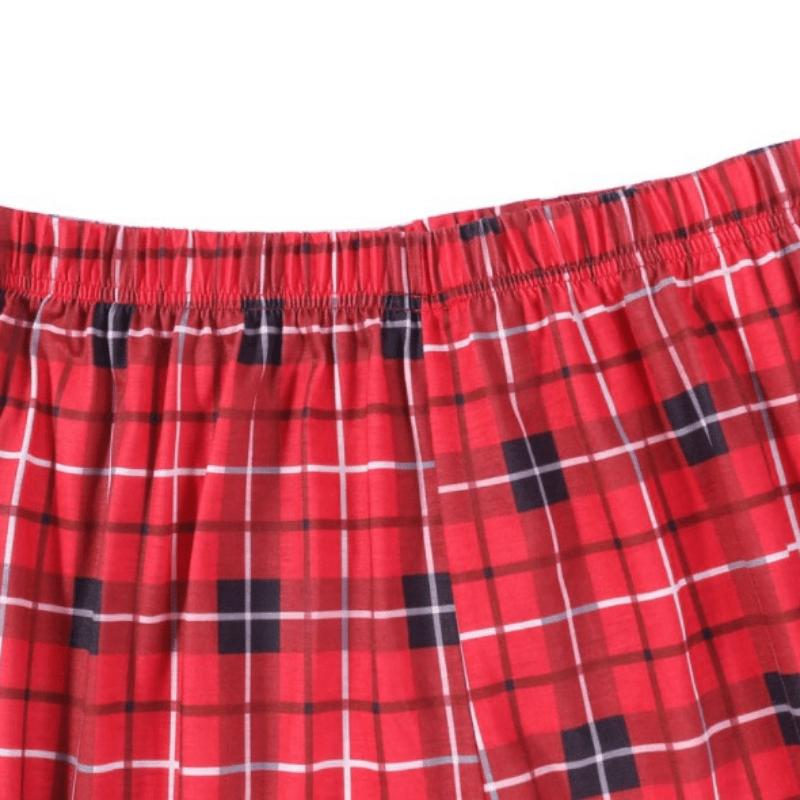 Nahaufnahme des elastischen Bunds und der Nähte an einer rot-schwarz-weißen Tartan-Weihnachtspyjamahose.