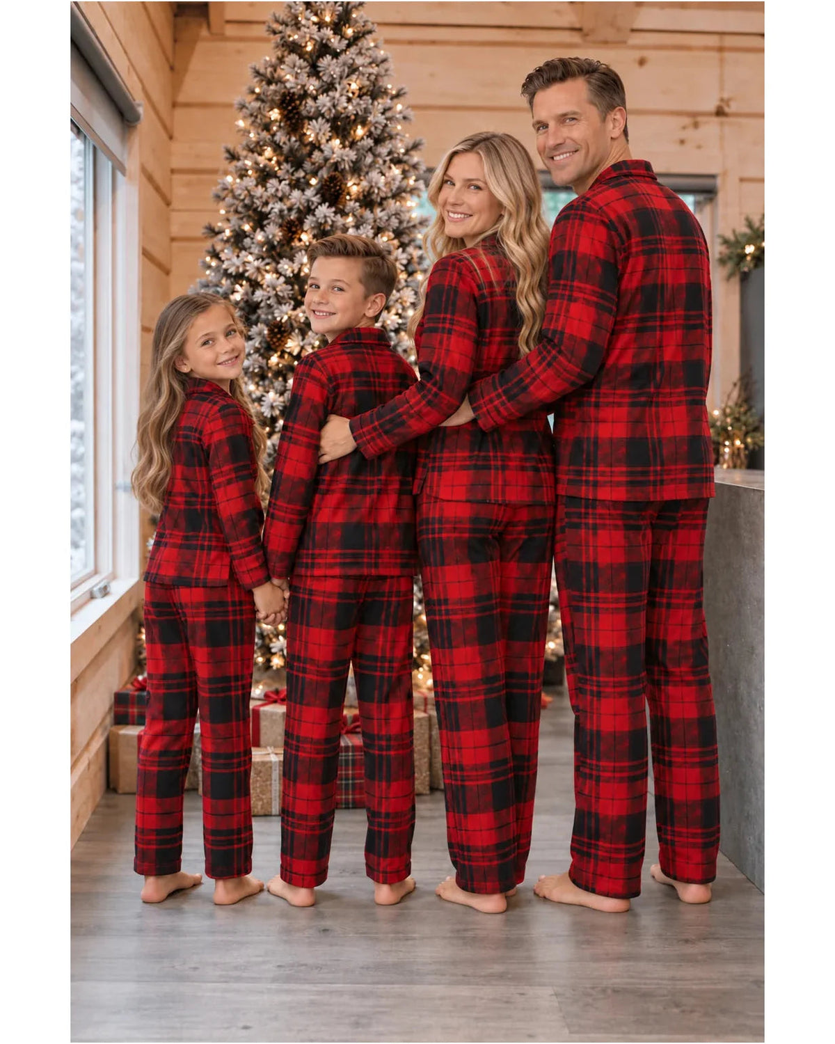 Back view of a family wearing red and black tartan pajama sets in a wood-paneled Christmas room.