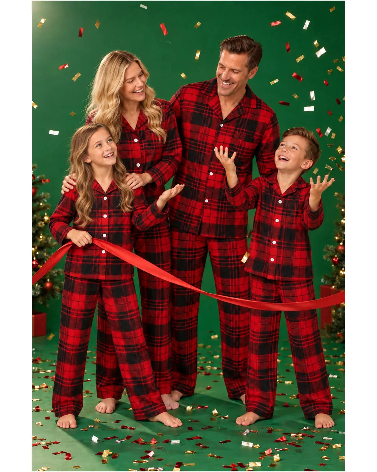 Family in red and black tartan pajamas holding a red ribbon under falling confetti against a green backdrop.