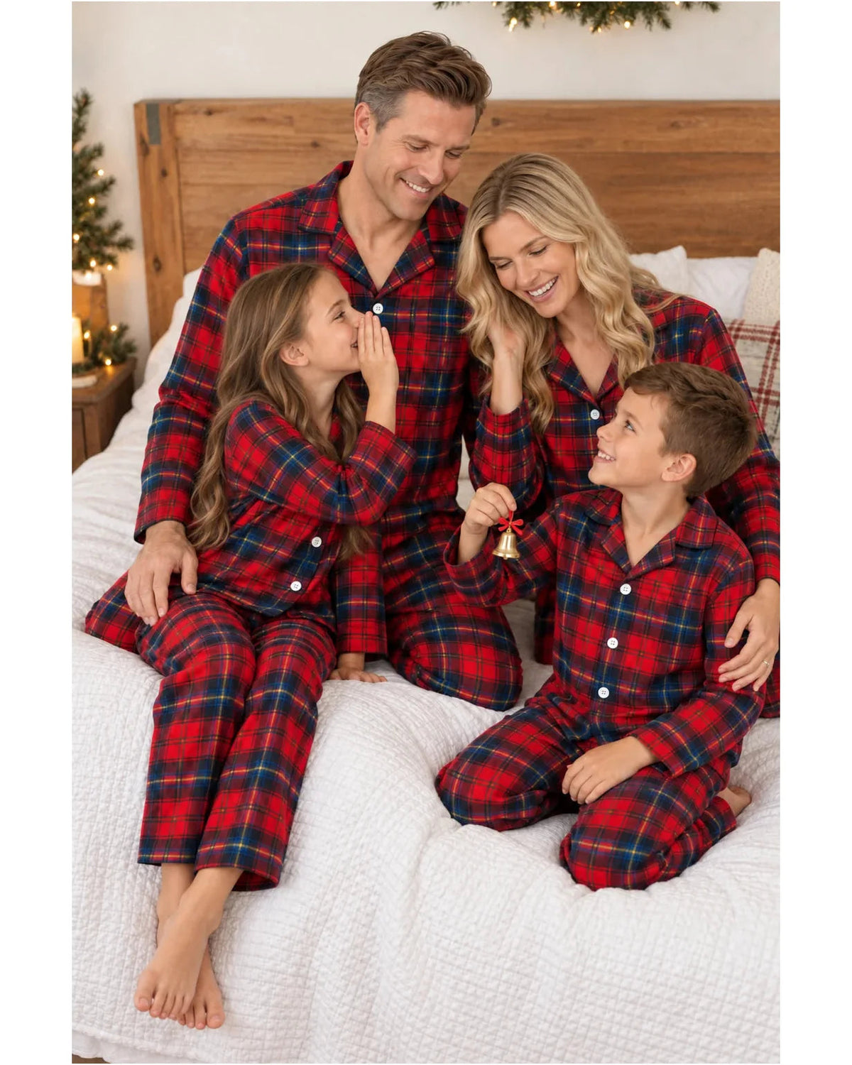 Family in red and blue plaid button-front pajamas gathered on a white bed.