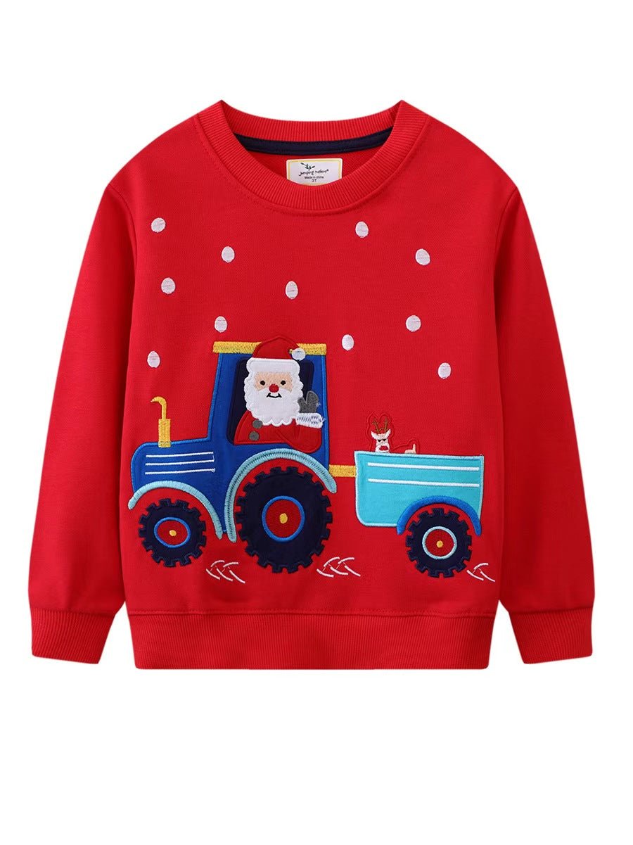 Vista frontale di una felpa natalizia rossa per bambini con Babbo Natale alla guida di un trattore blu, una renna nel rimorchio e puntini bianchi di neve.