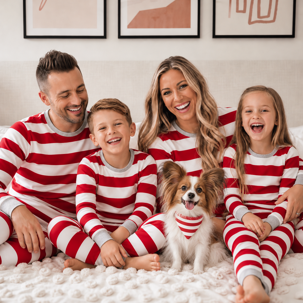 Family in red and white striped pajamas with a white and sable Papillon wearing a matching triangular striped bandana.