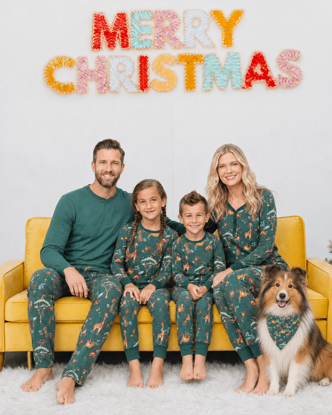 Family in green animal print Christmas pajamas on a yellow sofa, with a dog wearing a matching bandana.
