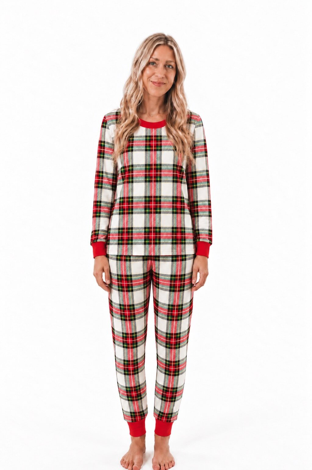 Donna in pigiama in tartan crema, rosso e verde con scollo e polsini rossi, su sfondo semplice.