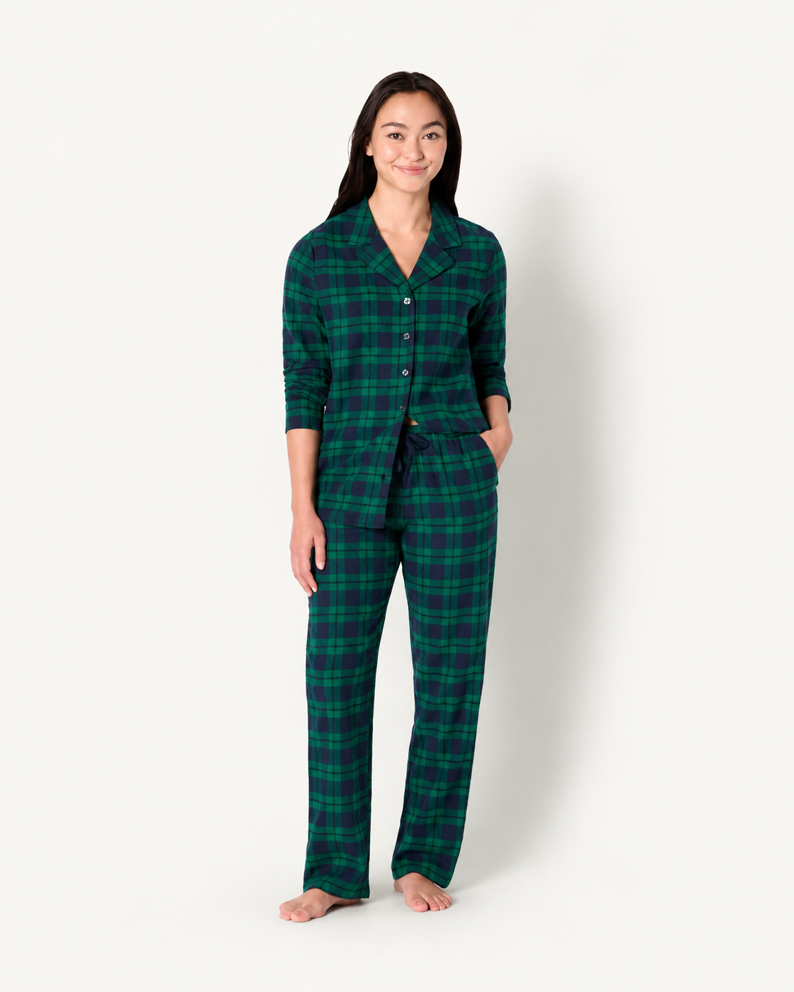 Front view of a woman wearing forest green and navy plaid pajamas with a button-front shirt and long pants.