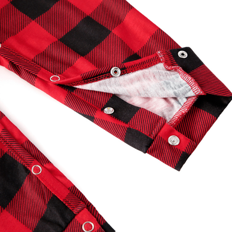 Close-up of snap closures on a red and black buffalo plaid baby sleeper.