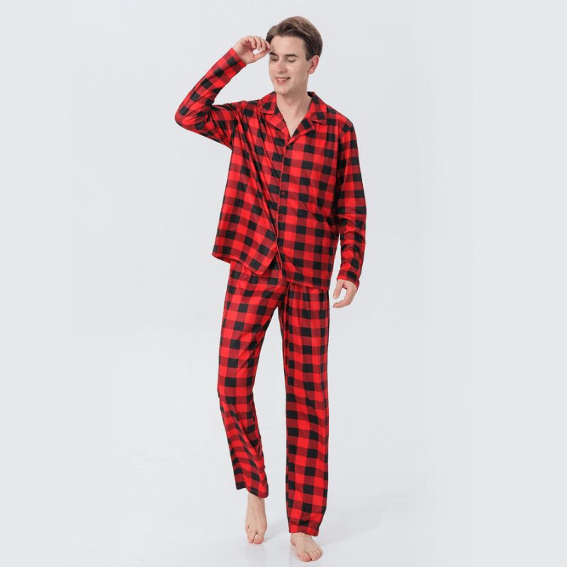 Man modeling red and black buffalo plaid button-front pajamas against a white background.