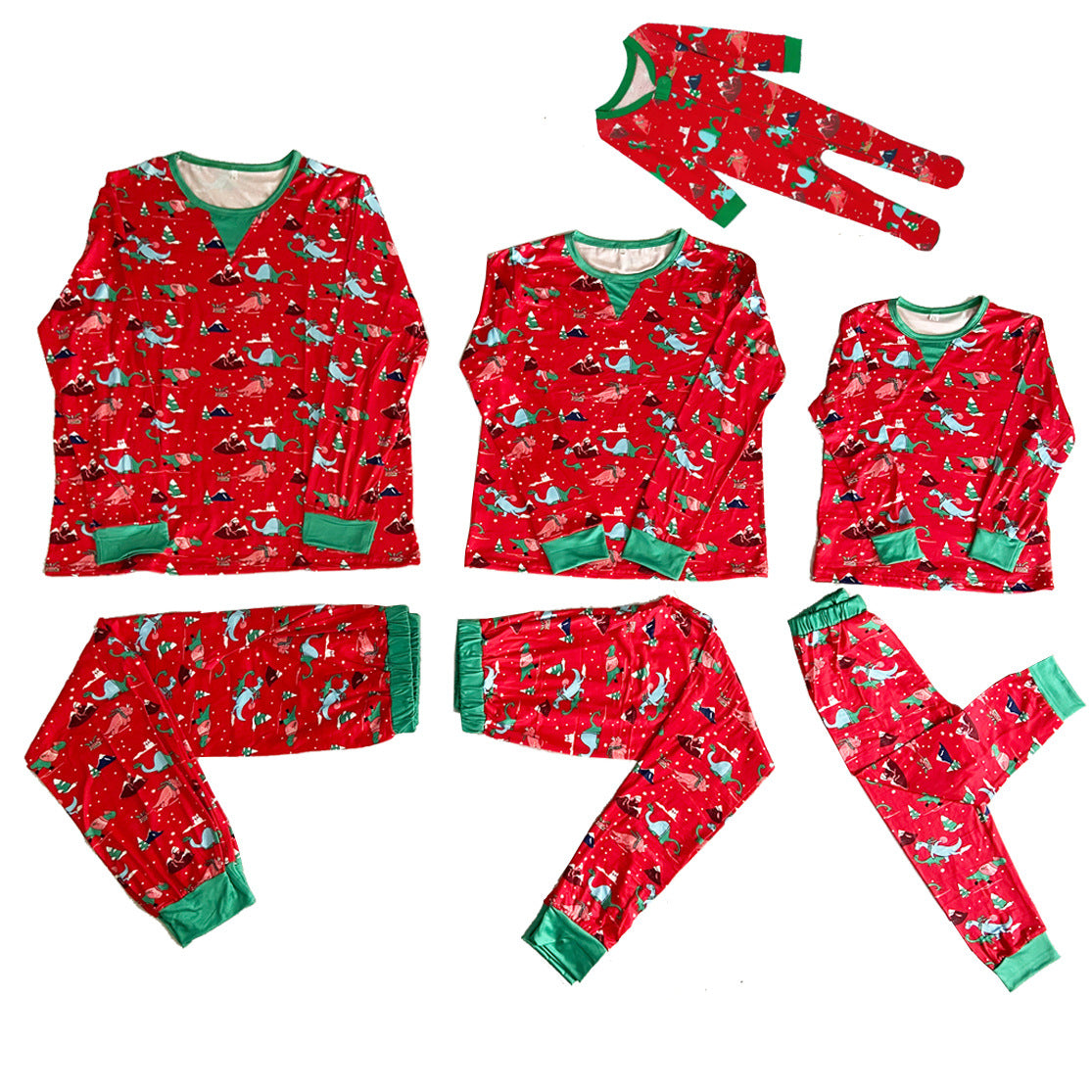 Flat lay of red dinosaur print family Christmas pajama sets with green cuffs and a matching footed baby sleeper.